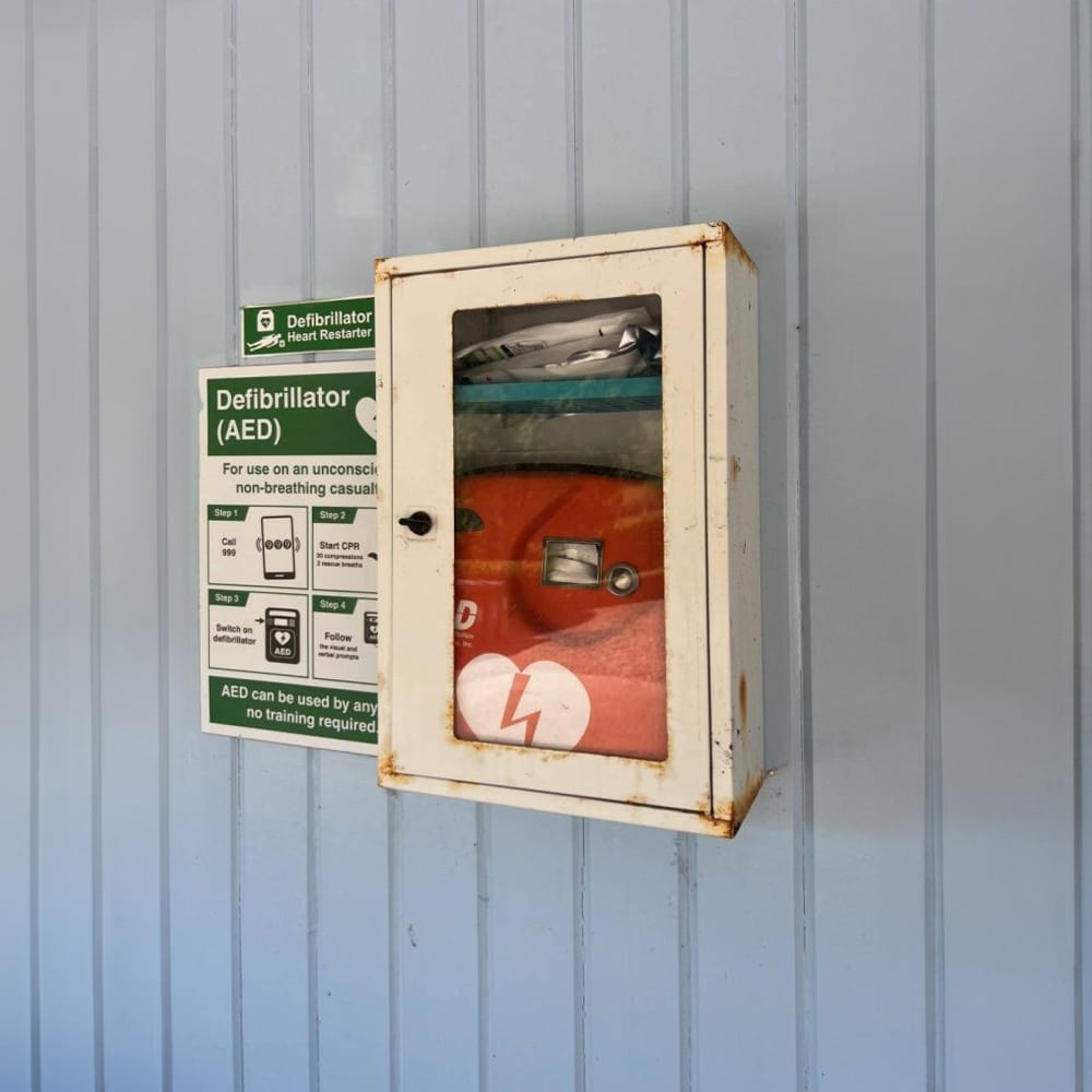 Should I store a defibrillator outdoors in an unheated cabinet?